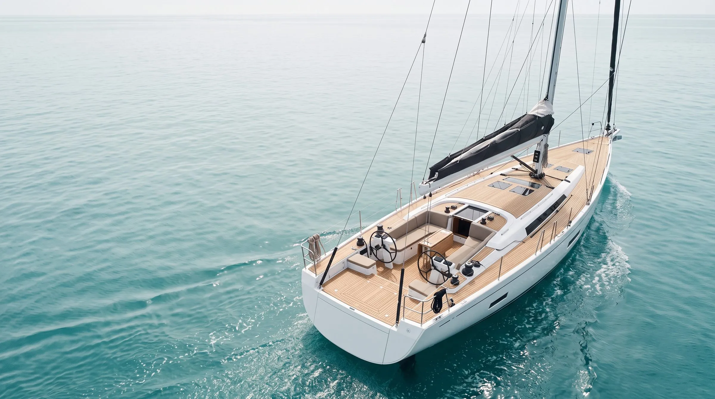 Teakdeck einer Segelyacht von oben, türkises Wasser